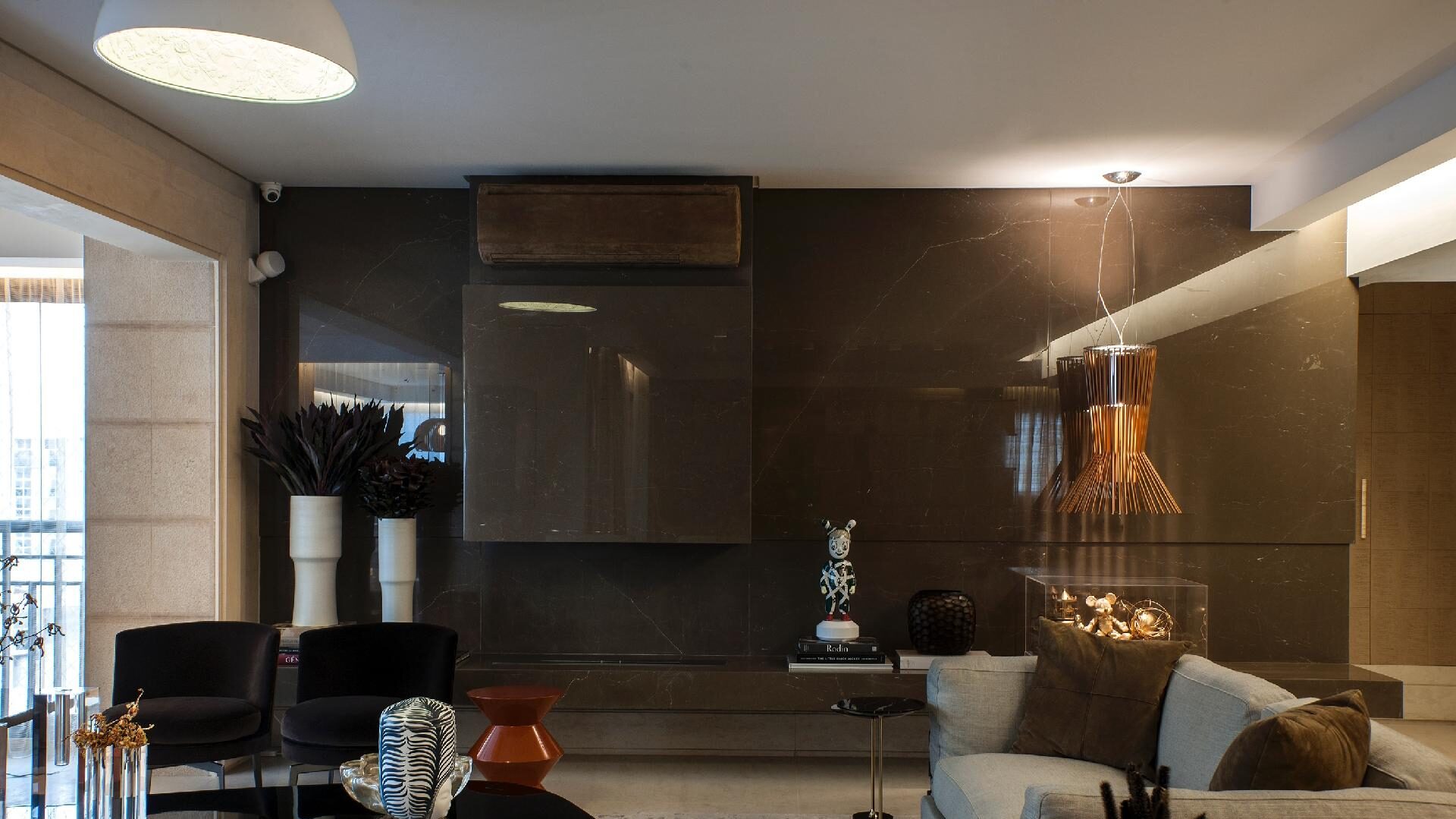 Combine luz natural com pontos de luz indireta (arandelas, fitas de LED, luminárias de chão). Ambientes bem iluminados parecem naturalmente mais espaçosos do que ambientes escuros ou com luz única no centro do teto.